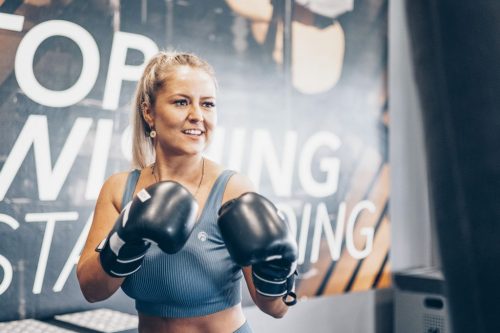 Fotografie einer Frau beim Boxtraining im Fitnessstudio.