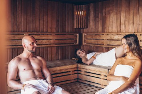 Fotografie einer Sauna mit zwei Frauen und einem Mann im Fitnessstudio.